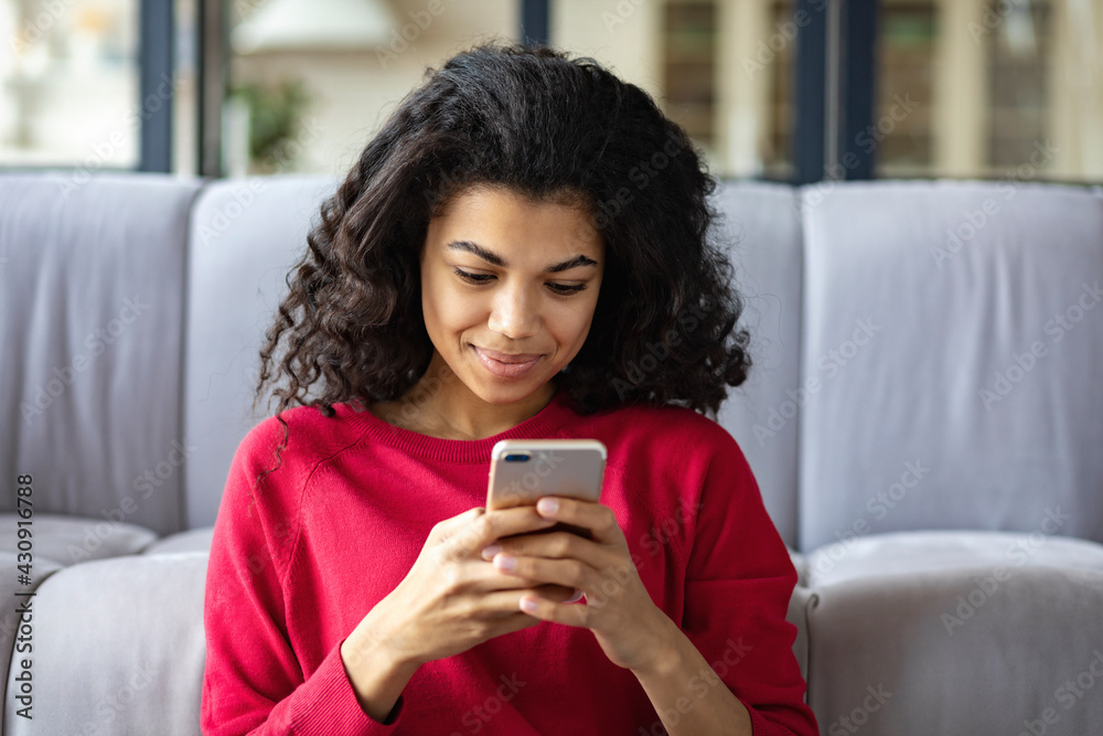 Beautiful young African American woman chatting on social networks using the phone Beautiful young African American woman chatting on social networks using the phone