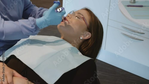 gloved Dentist inject female patient with local anesthetic, Dental clinic photo