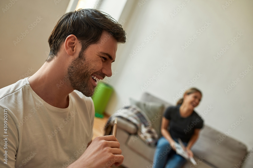 Obraz premium Young couple relaxes in modern living room and laughs