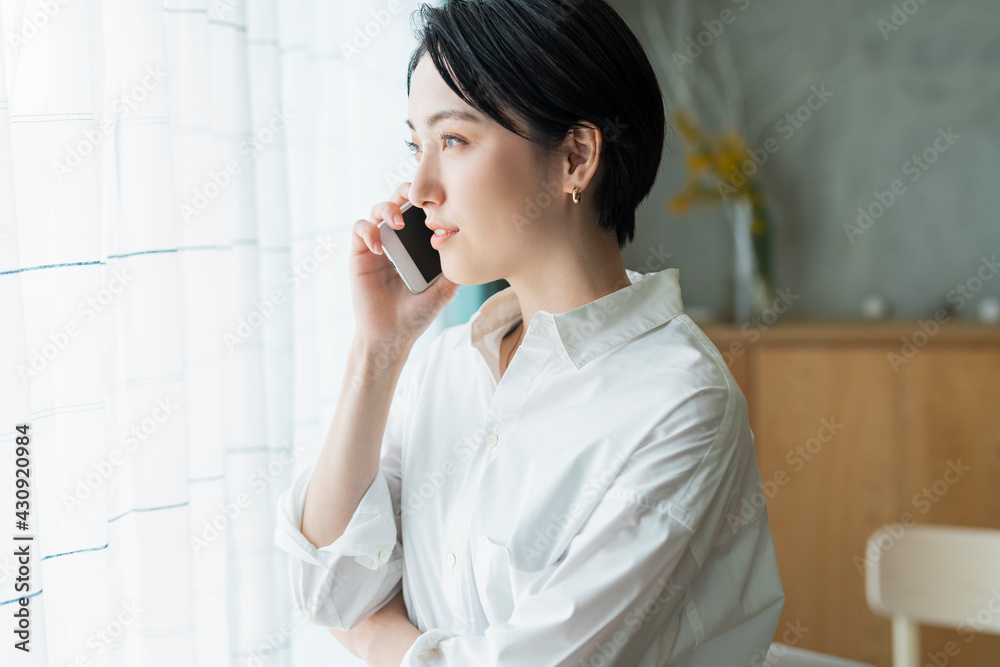 窓際で電話をする女性