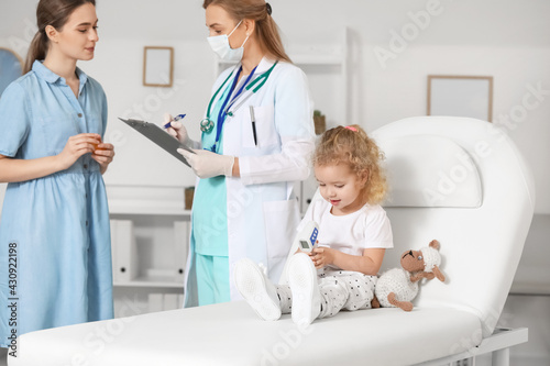 Woman with her little daughter visiting pediatrician in clinic