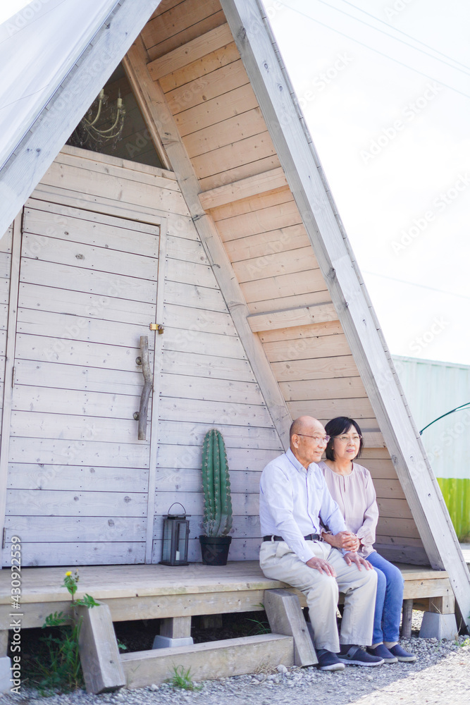 別荘の前に座るシニアの夫婦