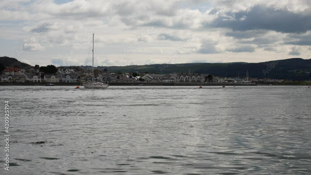 Small yacht boat floating on British rural fishing town coastline morning tide Small yacht boat floating on British rural fishing town coastline morning tide