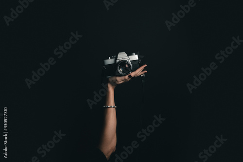 Woman's hand holding a film camera in studio