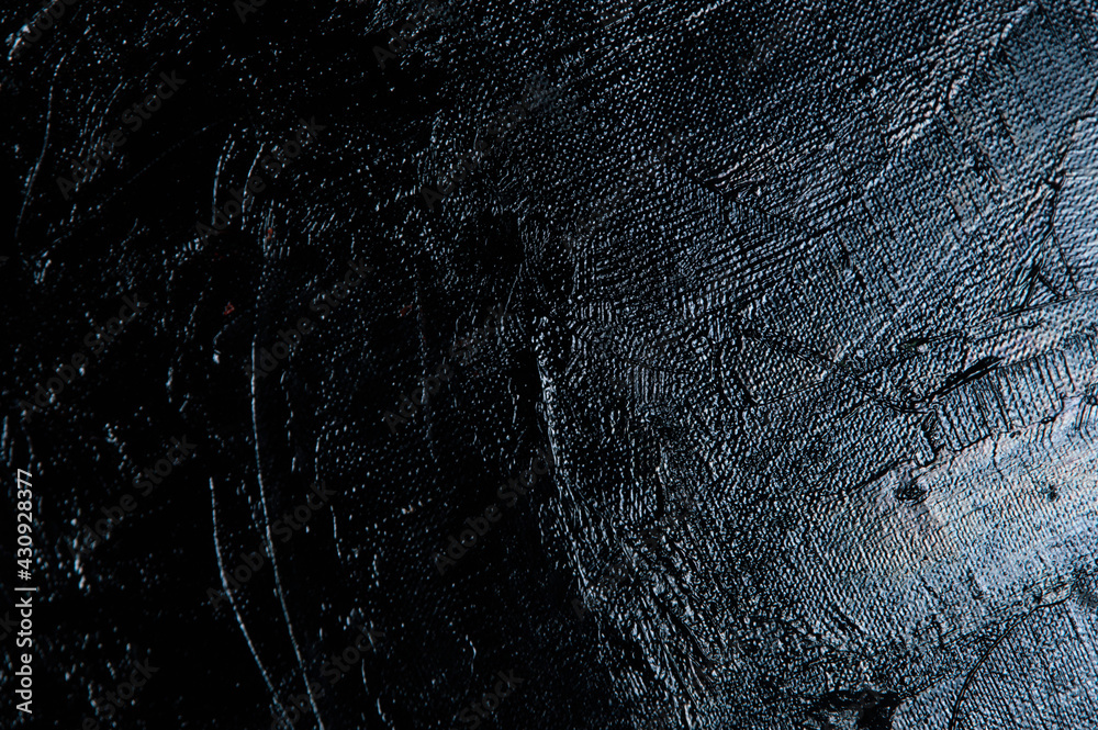 Fototapeta premium Dark creative background - rough linen canvas unevenly covered with black primer, reflections of light. Toning, blurring, selective focus.