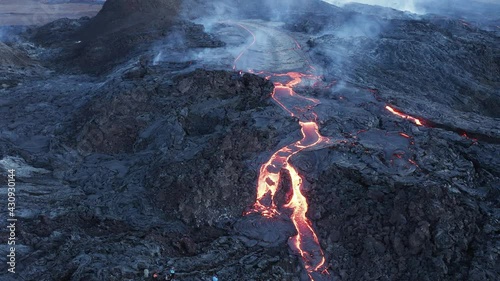 Tourist watching viscous lava stream at Fagradalsfjall volcano in Iceland photo