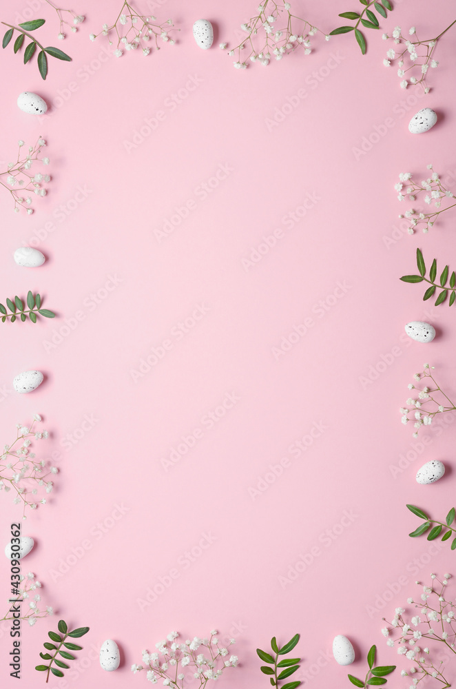 Eggs, gypsophila and green twigs on a pink background. Frame. Easter concept