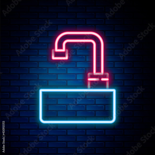 Glowing neon line Washbasin with water tap icon isolated on brick wall background. Colorful outline concept. Vector