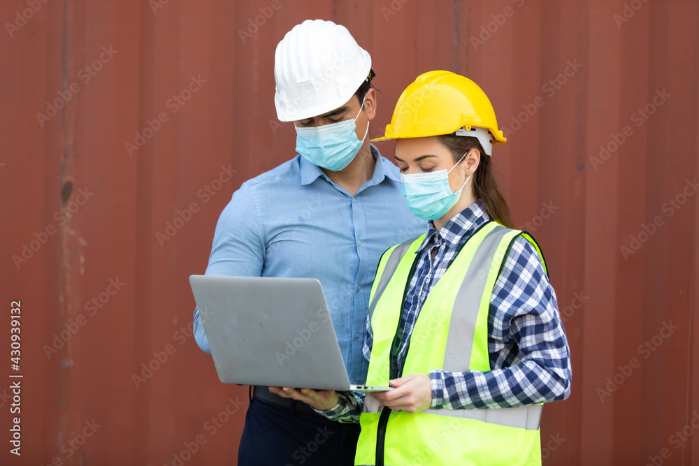 Technical expert in solar photovoltaic panels holding light bulb in hand and discussion with engineer woman in new project. Engineer wearing hygienic mask and protective hard hat. Technical expert in solar photovoltaic panels holding light bulb in hand and discussion with engineer woman in new project. Engineer wearing hygienic mask and protective hard hat.