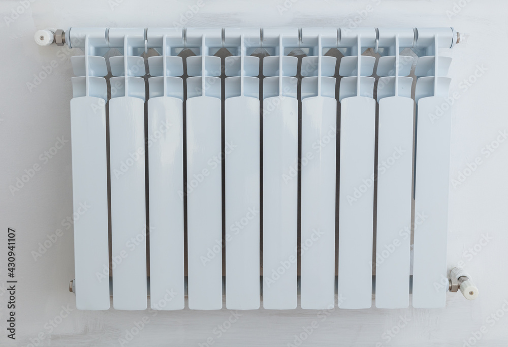 Installing a radiator on a white wall. Installing a radiator on a white wall.