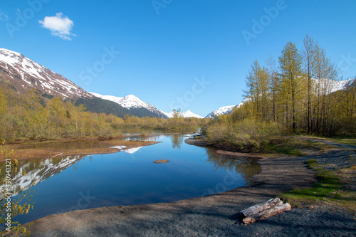 Portage Creek with snow covered mountains reflections in Turnagain Arm near Anchorage Alaska United States