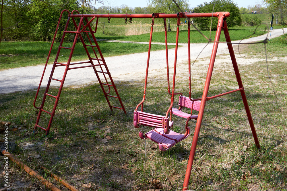 abandoned playground with red and pink swing abandoned playground with red and pink swing