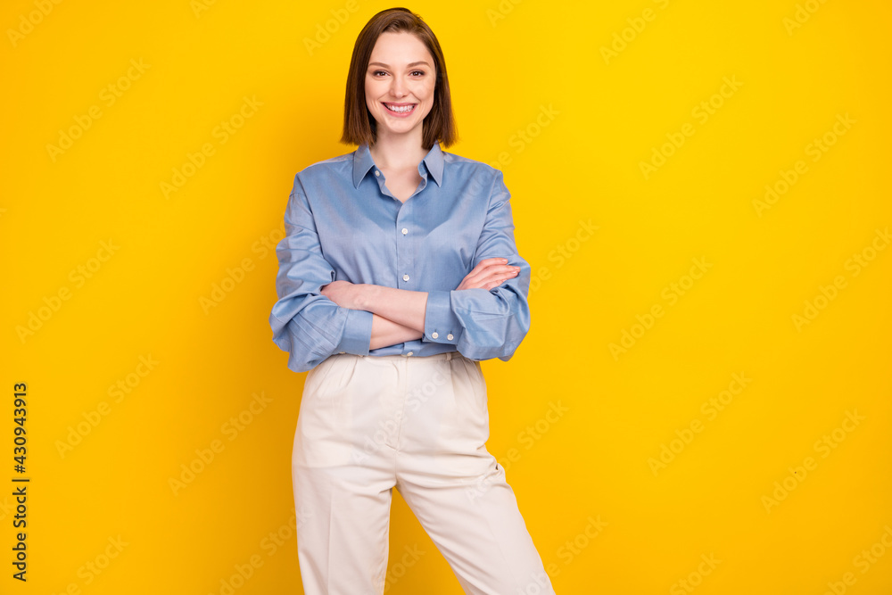 Photo of attractive confident young woman hold hands crossed smile isolated on shine yellow color background Photo of attractive confident young woman hold hands crossed smile isolated on shine yellow color background