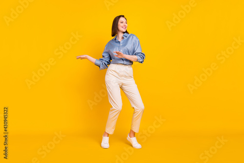 Full length photo of attractive young charming woman look empty space dance enjoy isolated on yellow color background