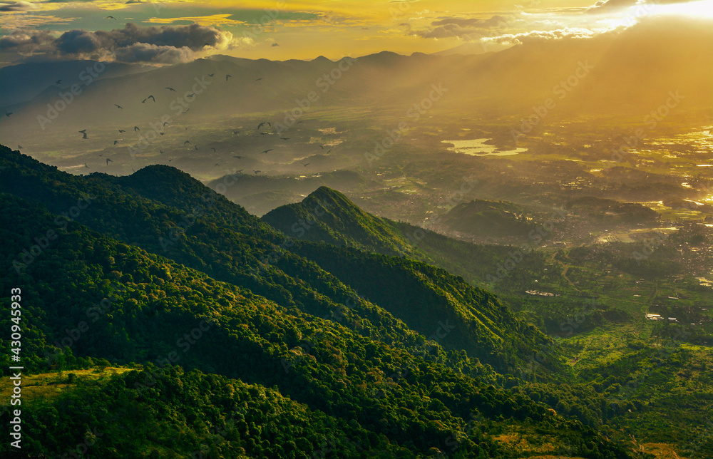 Panoramic landscape of great Indonesia mountain range during an autumn morning from the top of the mountain. Aerial view of misty mountains at sunrise