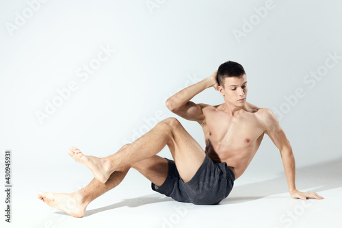 morning exercises young athlete in gray shorts and an inflated torso fitness