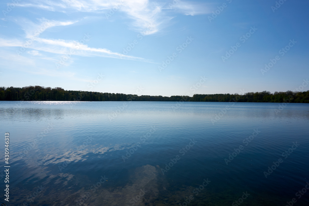 blue water quarry pond lake under blue sky and sunshine