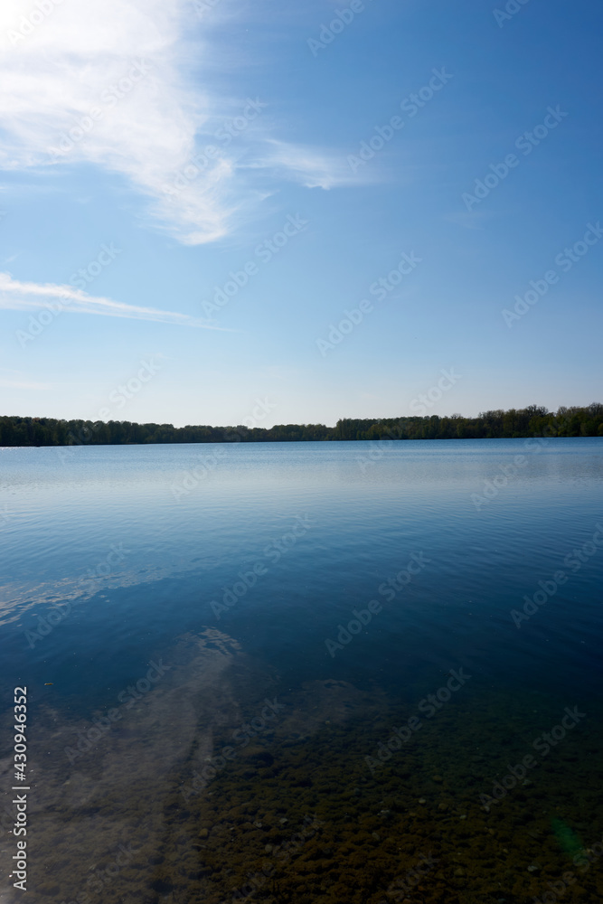 blue water quarry pond lake under blue sky and sunshine