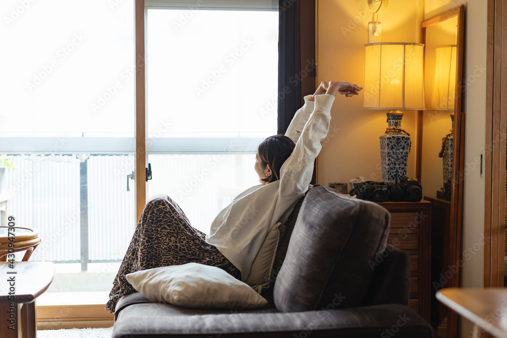 リビングでストレッチをする日本人女性 リビングでストレッチをする日本人女性