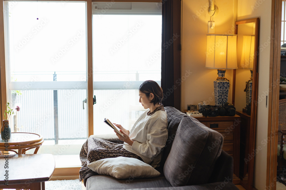 リビングで読書する日本人女性 リビングで読書する日本人女性