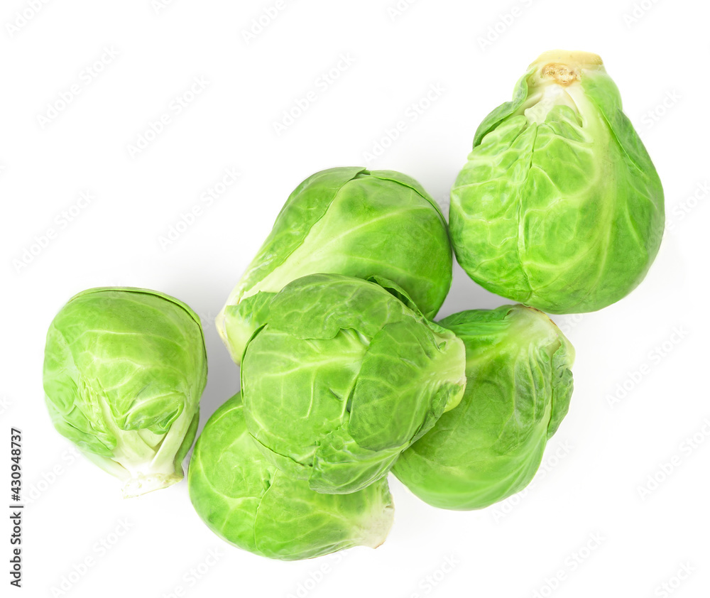 Fototapeta premium Heap of Brussel Sprouts isolated on white background. Fresh raw brussel cabbage, whole and half. Top view .