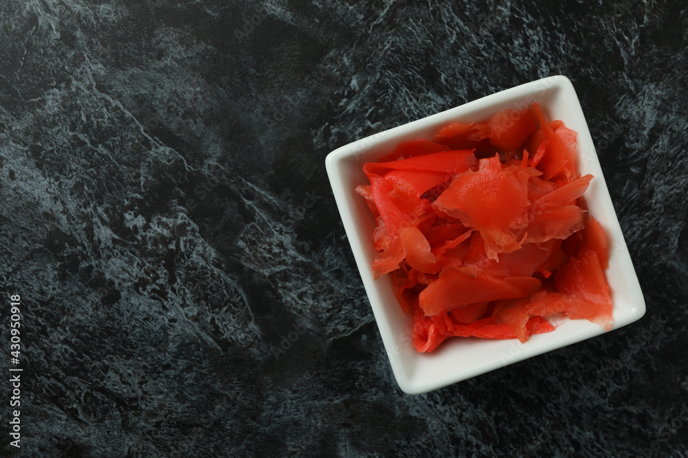 Bowl with red pickled ginger on black smokey background Bowl with red pickled ginger on black smokey background