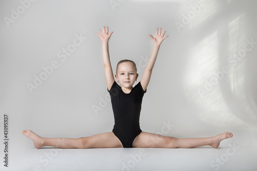 young gymnast in black canopy demonstrates flexibility twine
