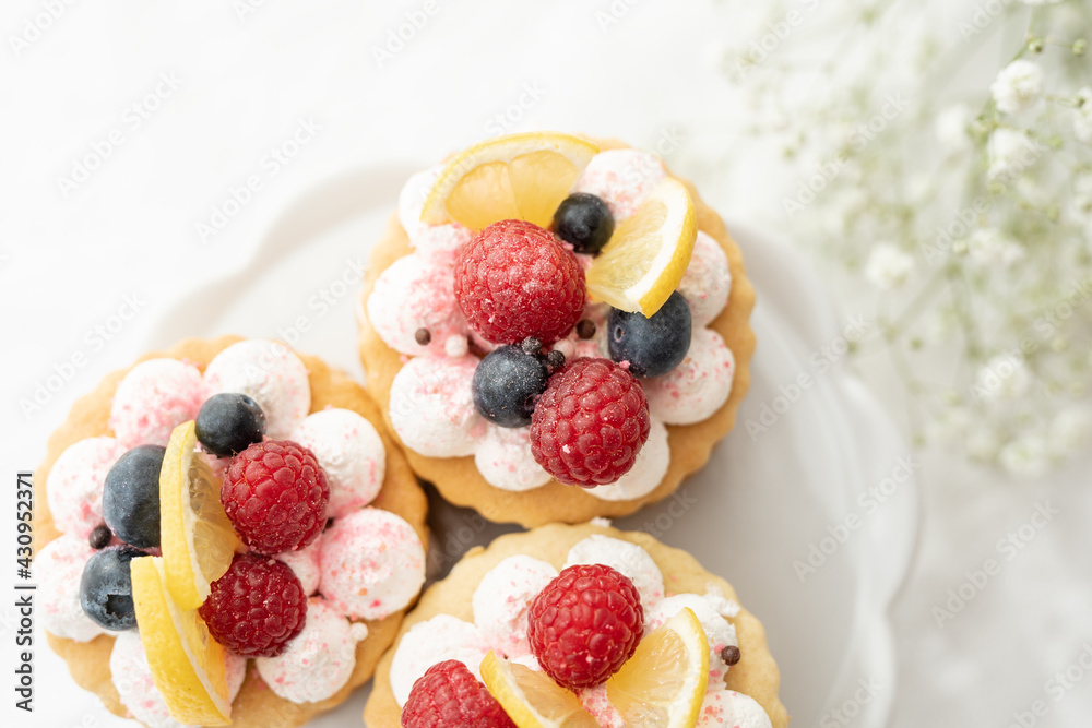 selection of sweet baked cream edible flowers and fruit dessert cakes for mothersday, wedding, birthday, paerty celebration. viola odorata cake. 