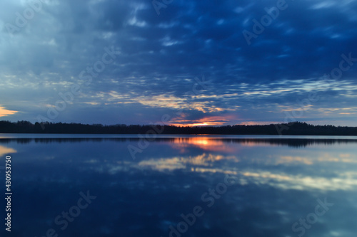 Sunset sky background. Dramatic gold sunset with evening sky clouds over the lake. Stunning sky clouds in the sunrise. Sky landscape. Panoramic view.
