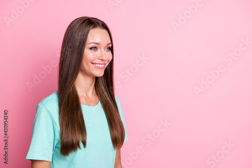 Photo portrait of beautiful girl in blue outfit smiling happy looking empty space isolated on pastel pink color background