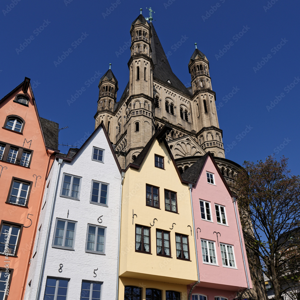small colorful houses in front of the church of great st. martin in cologne's old town