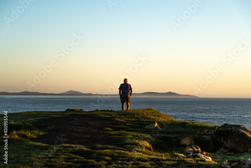 Rear View of Old Man Standing in the Edge of a Hill Looking the Sunrise.Lifestyle and Nature Concept