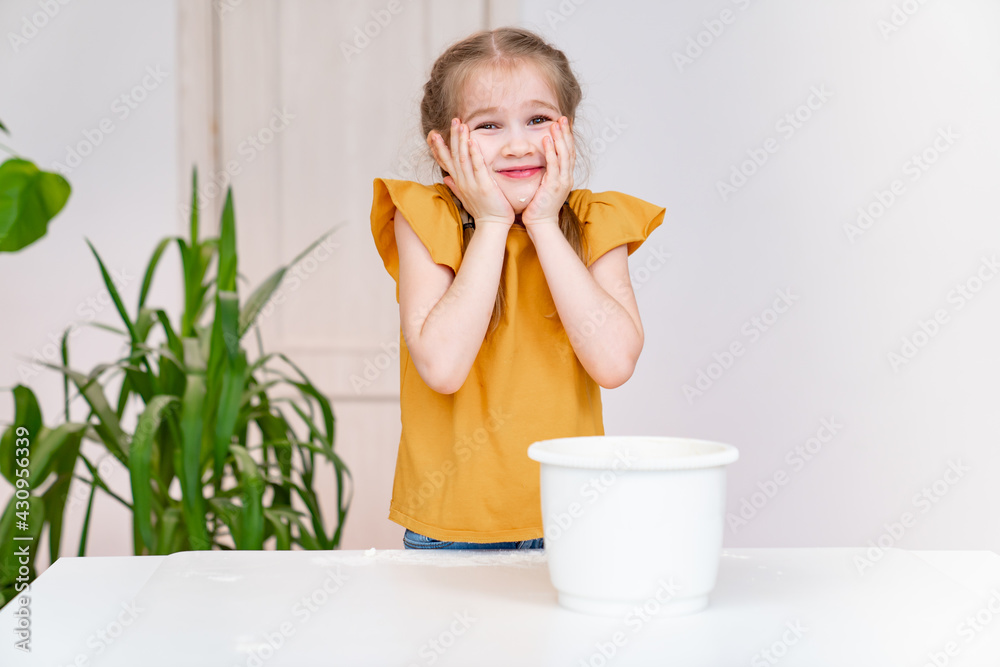 little funny girl holds hands in flour over her cheeks. children's culinary hobby. Simple and delicious recipe. Culinary school. little funny girl holds hands in flour over her cheeks. children's culinary hobby. Simple and delicious recipe. Culinary school.