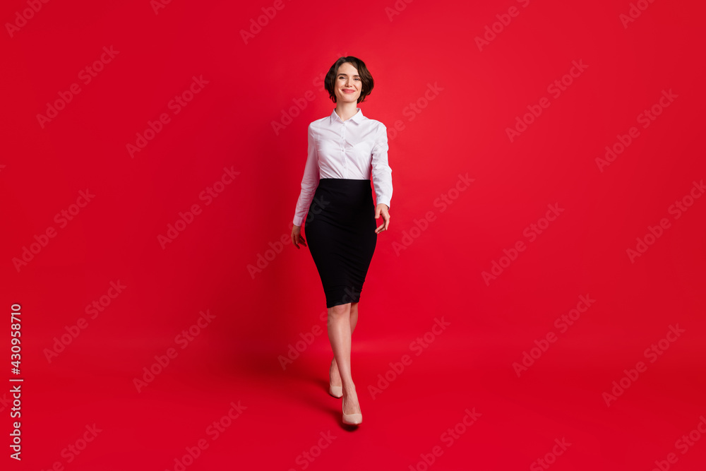 Full length body size photo business woman walking forward in stilettos isolated vibrant red color background