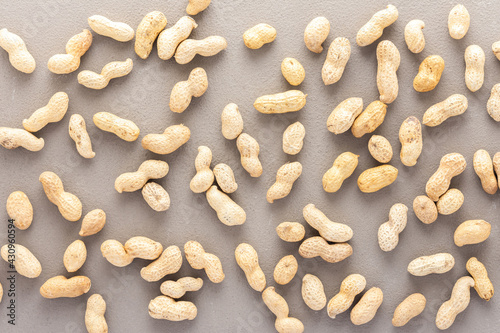 Legumes are scattered in the background, natural background of peanuts, top view