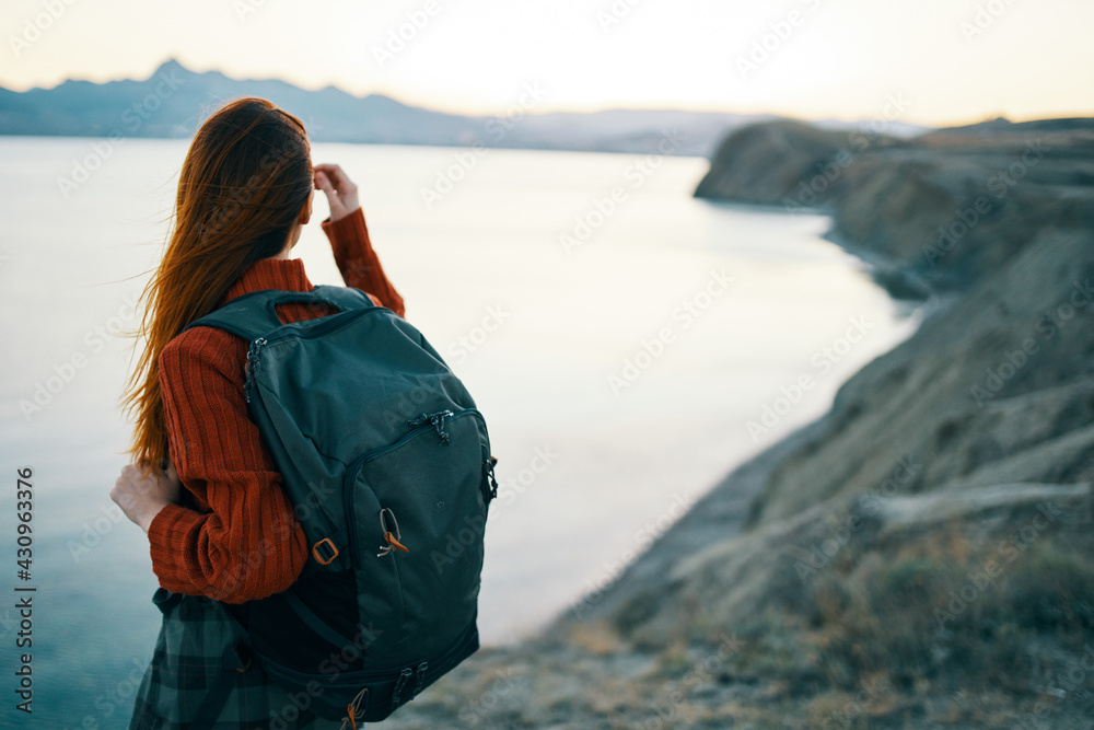 woman in red sweater with backpack and travel tourism sea mountains woman in red sweater with backpack and travel tourism sea mountains