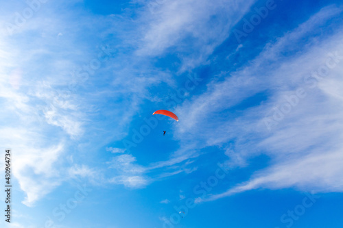 Paragliding in blue sky. Parachute with paraglider is flying. Extreme sports, freedom concept