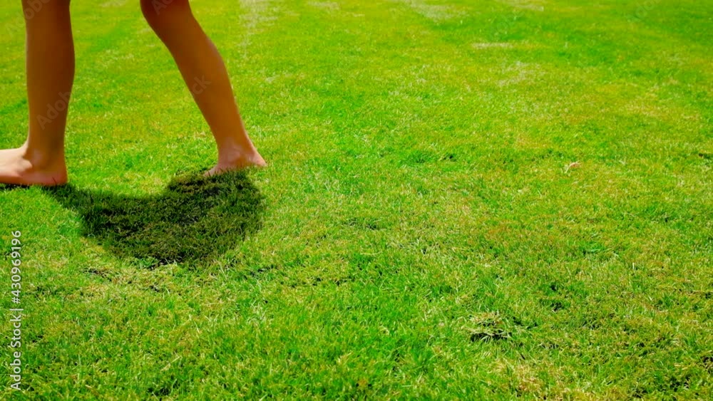 Child's feet on the grass. Selective focus. Child's feet on the grass. Selective focus.