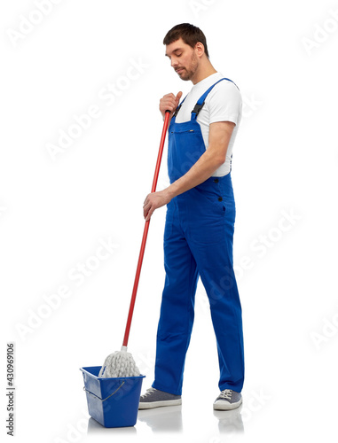 profession, service and people concept - male worker or cleaner in overall cleaning floor with wet mop and bucket over white background