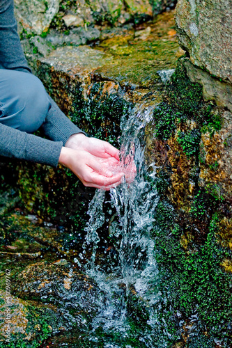 A person by a stream of mountain water.