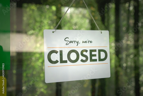 Signboard, Sorry We Are Closed hanging on the door of a shop.