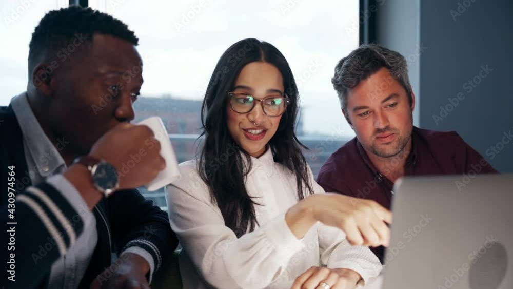 Diverse group of colleagues working on collaboration project typing on laptop in office