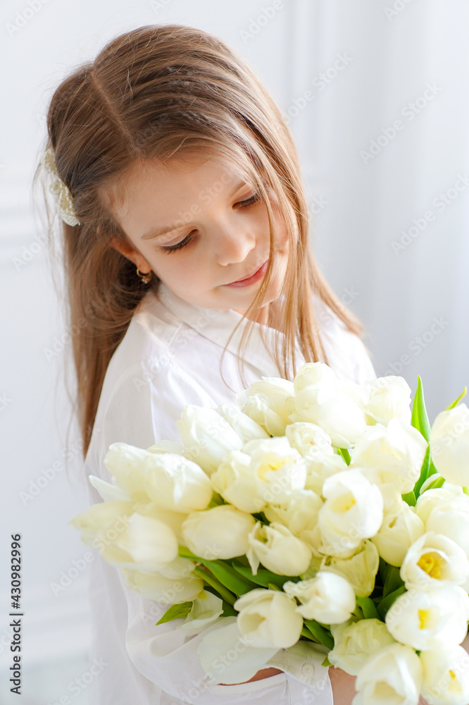 Portrait of beautiful pretty girl with white flowers tulips sitt Portrait of beautiful pretty girl with white flowers tulips sitt