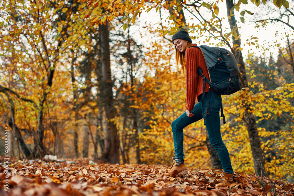 beautiful woman with a backpack in the park on nature landscape fallen leaves bottom view