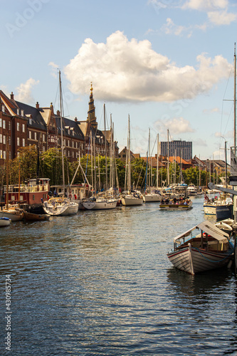 Traveling along Christianshavn canal in Copenhagen with church spire in distance.