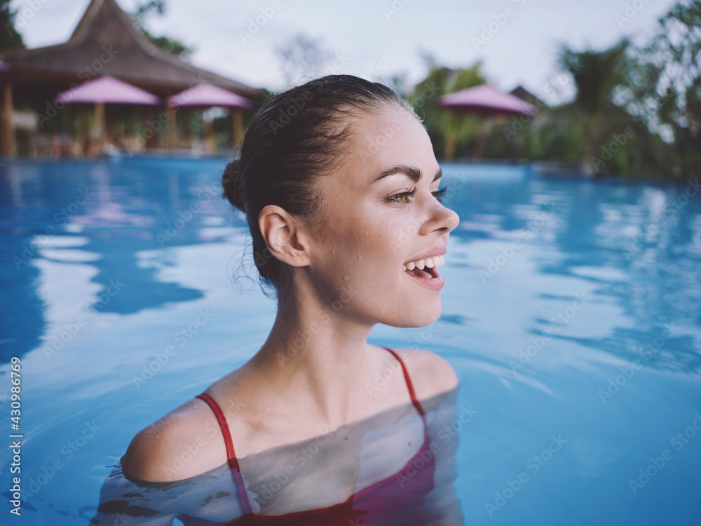 happy woman smiling and looking aside swimming in the pool in nature