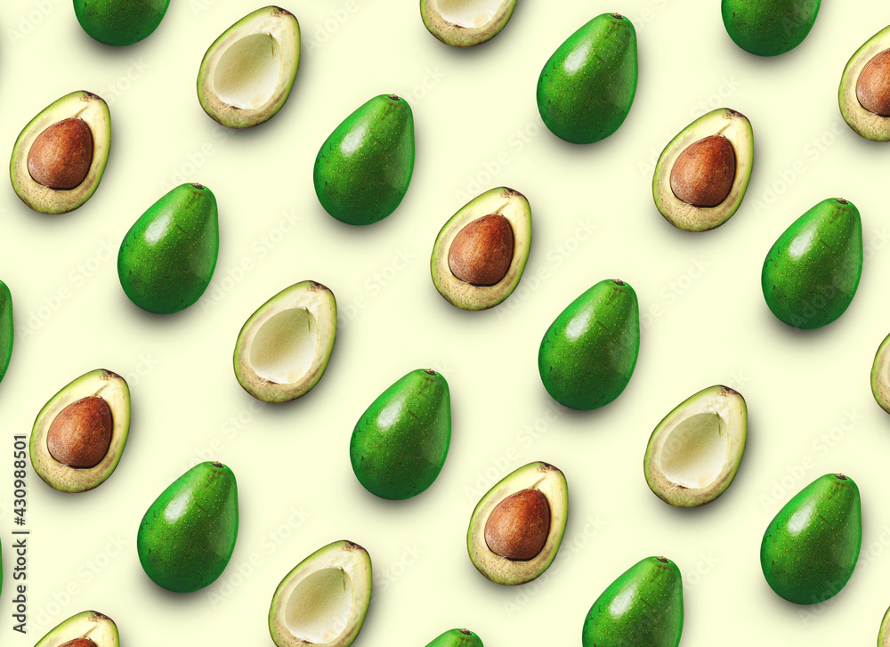 Avocado cut in half with bone isolated colored background. Avocado on a pink background Avocado cut in half with bone isolated colored background. Avocado on a pink background