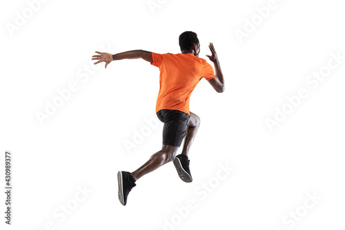 Sportive African-American man, athlete running isolated over white background. photo