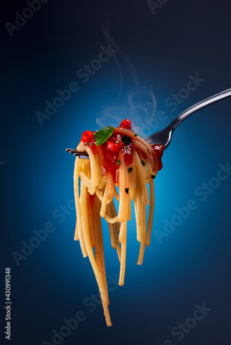 hot spaghetti with ketchup and herbs on a fork