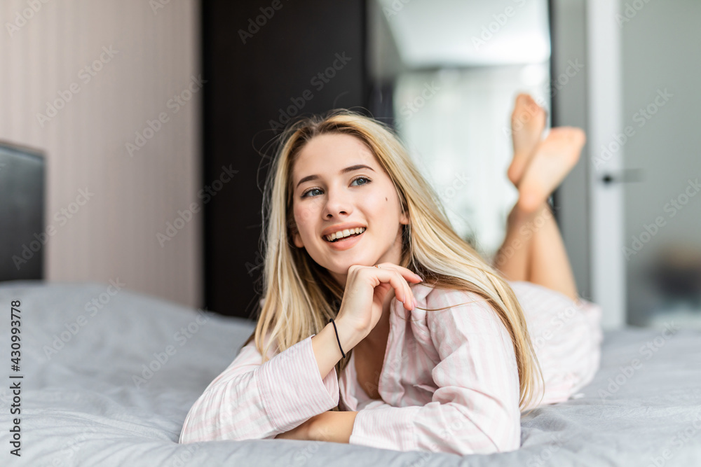 Pretty young woman lying down on her bed at home Pretty young woman lying down on her bed at home